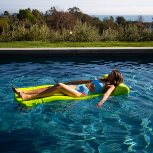 
                  
                    Load image into Gallery viewer, Woman floating on a stunning Neon Green pool float.
                  
                